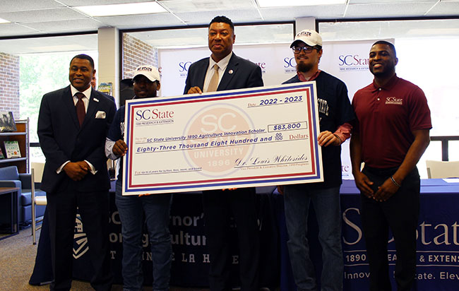 The SC State delegation brought a giant tuition check for the signees.